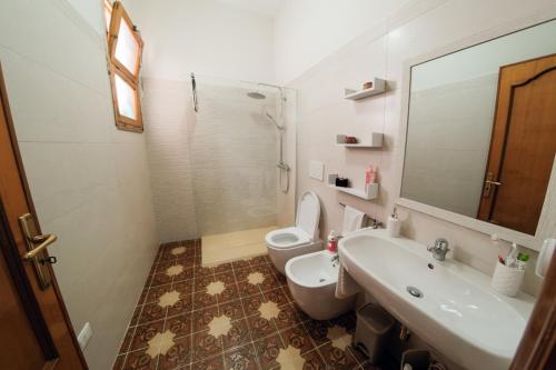 uma casa de banho com um lavatório, um WC e um espelho. em Civico 53 em Castro di Lecce