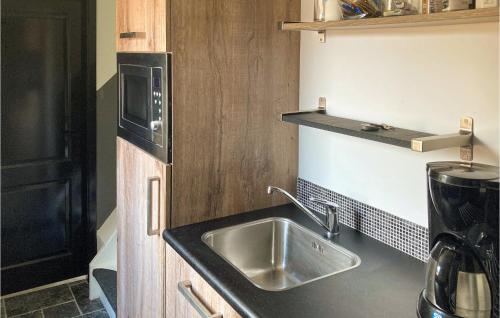 a kitchen with a sink and a microwave at Gorgeous Home In Bunschoten-Spakenb in Bunschoten
