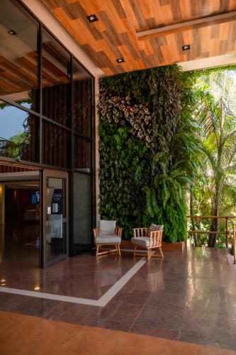 an outdoor patio with chairs and a green wall at Hotel Saint George in Puerto Iguazú