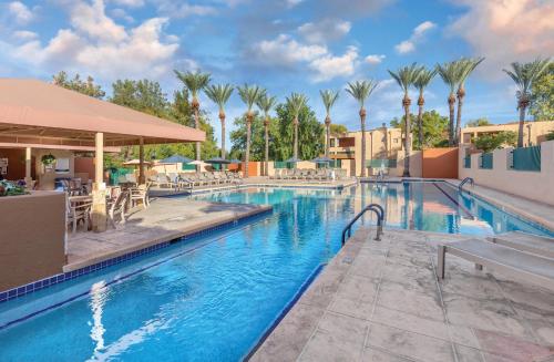 a swimming pool at a resort with palm trees at Orange Tree Resort in Scottsdale
