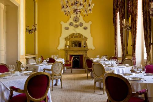 a dining room with tables and chairs and a fireplace at Pavillon Winter Luxor in Luxor