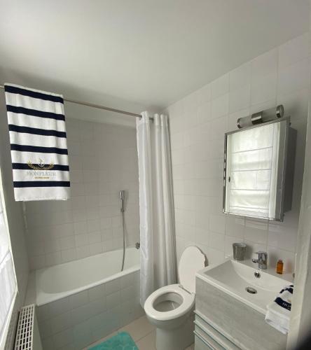 une salle de bain blanche avec des toilettes et un lavabo dans l'établissement Chambre d’hôtes du Carré des Arts, à Honfleur