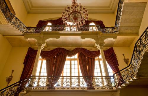 a balcony with a chandelier and a window at Pavillon Winter Luxor in Luxor