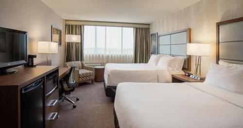 Cette chambre comprend deux lits et une télévision. dans l'établissement Holiday Inn Winnipeg-South, an IHG Hotel, à Winnipeg