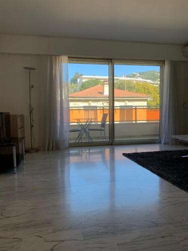 uma sala de estar vazia com uma grande janela e vista para um edifício em Cannes Grand Studio Terrasse em Cannes