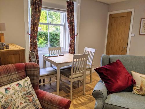 uma sala de estar com mesa e cadeiras em Kinloch Rannoch Holiday Cottage em Kinloch Rannoch