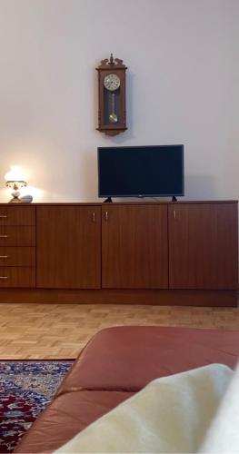a room with a tv and a clock on a wall at Landhaus nähe Neusiedler See in Jois