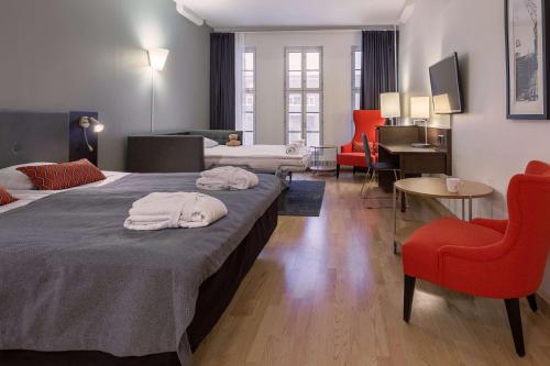 una camera d'albergo con due letti e una sedia rossa di Scandic Grand Marina a Helsinki