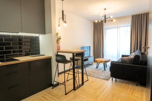 a kitchen and living room with a table and a couch at Stylchyn 90 Apartamenty nad Jeziorem Czorsztyńskim in Kluszkowce