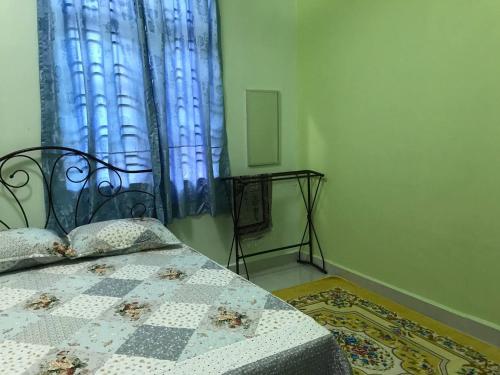 um quarto com uma cama com uma cortina azul em Tok Chik Homestay em Sik