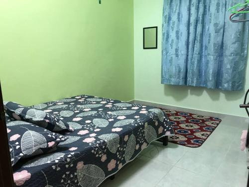 1 dormitorio con cama y alfombra en Tok Chik Homestay en Sik