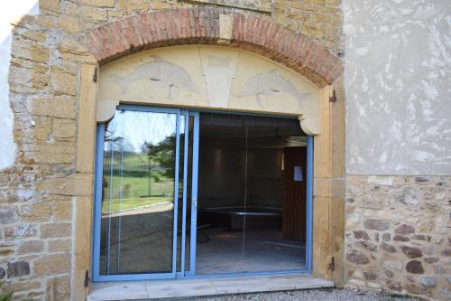 a stone building with a window with dolphins on it at Gite Stone & Spa in Chasselay