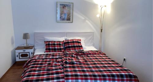 a bed with a plaid blanket and two pillows at Landhaus nähe Neusiedler See in Jois
