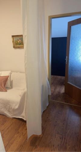 a bedroom with a white bed and a mirror at Landhaus nähe Neusiedler See in Jois