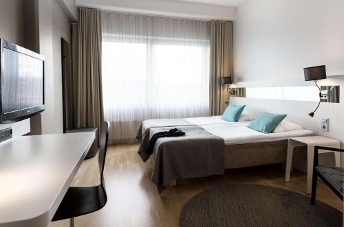 Scandic Julia في توركو: غرفة فندقية بسرير وتلفزيون بشاشة مسطحة