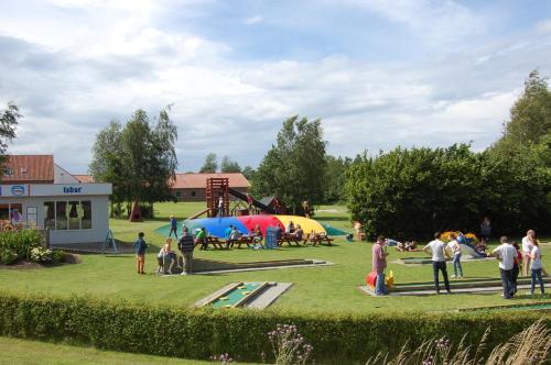 a group of people in a park with a playground at Nordgården Pension in Onsbjerg