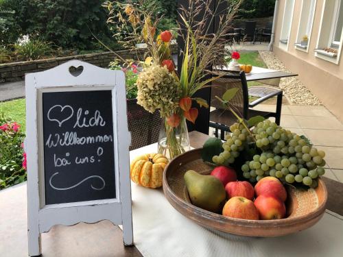 a bowl of fruit on a table with a sign at Villa zur Schmied'n in Ehrenhausen