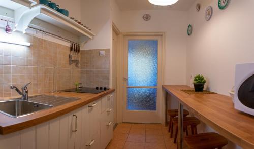 a kitchen with a sink and a counter with a window at Helikon 32 Apartman Keszthely in Keszthely