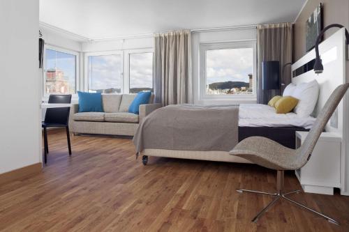 um quarto com uma cama, uma cadeira e um sofá em Scandic Haugesund em Haugesund
