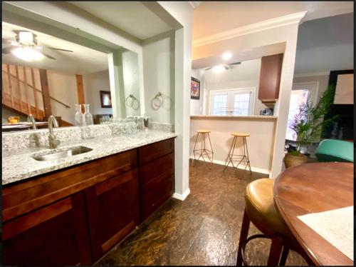 a kitchen with a sink and a table and a dining room at Private Bedroom Suite - Communal House near Integris in Oklahoma City