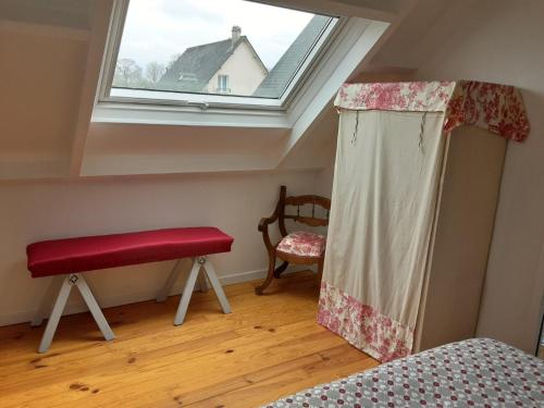 1 dormitorio con banco rojo y ventana en Le Petit Montceaux, en Le Val-Saint-Père