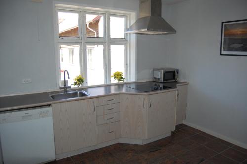 a kitchen with a sink and a microwave at Nordgården Pension in Onsbjerg