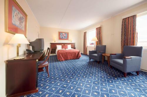 ホニングスヴォーグにあるScandic Honningsvågのベッド、デスク、椅子が備わるホテルルームです。