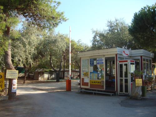 a phone booth in a park with trees in the background at Camping Tellina in Manfredonia