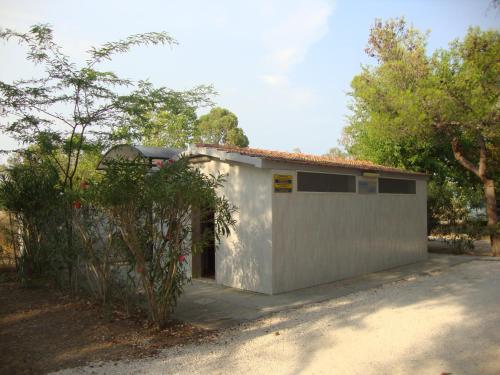 a small white building with a garage at Camping Tellina in Manfredonia