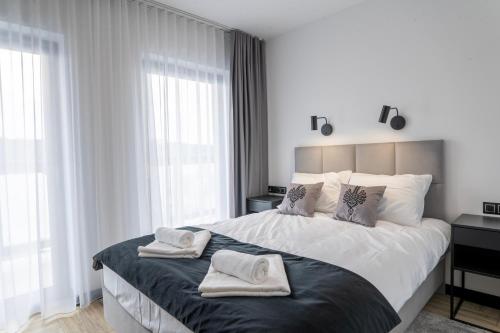 a bedroom with a large bed with two towels on it at Stylchyn 90 Apartamenty nad Jeziorem Czorsztyńskim in Kluszkowce