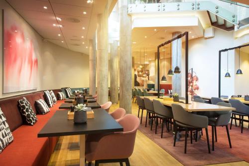 a restaurant with tables and chairs in a room at Scandic Grensen in Oslo