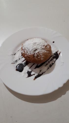a donut on a white plate on a table at Dniprovski Zori in Kremenchuk