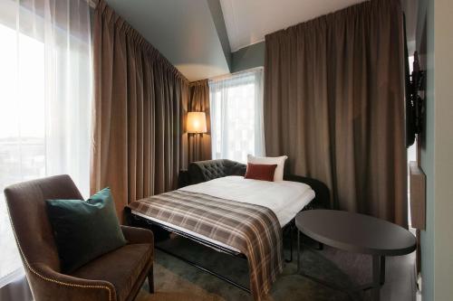 Habitación de hotel con cama y silla en Scandic Lillestrøm en Lillestrøm