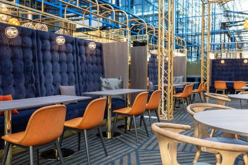 a restaurant with tables and chairs in a room at Scandic Helsinki Airport in Vantaa
