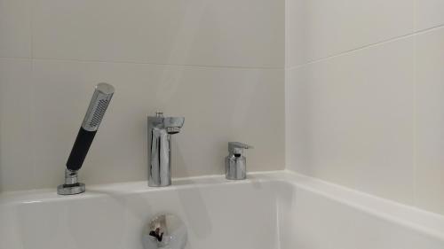 - un évier de cuisine avec un couteau et deux robinets dans l'établissement Appart ARCAIM, climatisé 90m2, 4 chambres, à 200m de la plage, à Argelès-sur-Mer