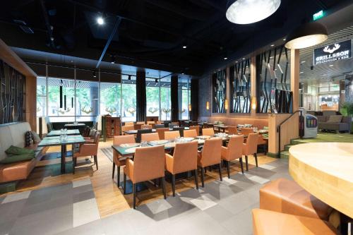 a dining room with tables and chairs and windows at Scandic Tampere Hämeenpuisto in Tampere