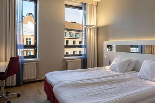 ヘルシンキにあるスカンディック カイサニエミのベッド1台と窓2つが備わるホテルルームです。