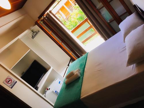 a bed in a room with a window at Pousada Azul Banana - Camburi in Camburi