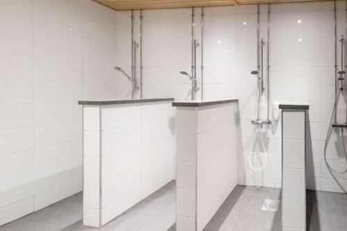 uma casa de banho com paredes de azulejos brancos e cabinas de duche em Scandic Atrium em Turku