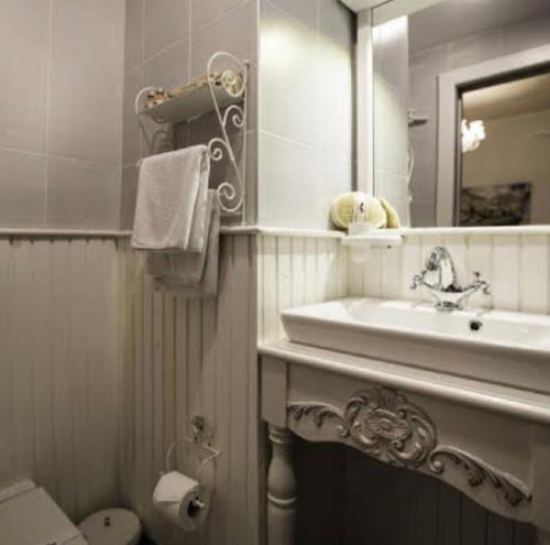 a bathroom with a sink and a mirror and a toilet at The White Hotel Alaçatı in Alaçatı