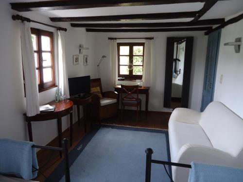 een woonkamer met een witte bank en een bureau bij Am Alten Fronhof in Bergisch Gladbach