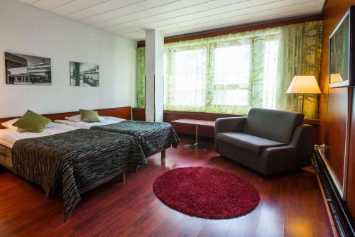 a hotel room with a bed and a chair at Scandic Polar in Rovaniemi