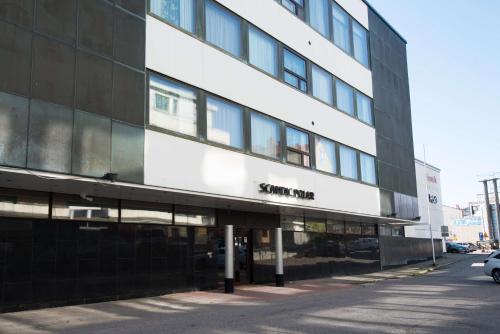 ein Gebäude auf einer Straße mit einem Auto vor der Tür in der Unterkunft Scandic Polar in Rovaniemi