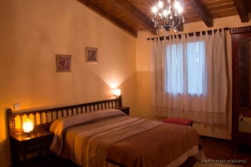 - une chambre avec un grand lit et une fenêtre dans l'établissement La Casa de la Abuela Petra, à Solarana