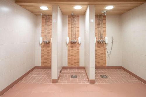 a bathroom with two shower stalls in a building at Scandic Joensuu in Joensuu