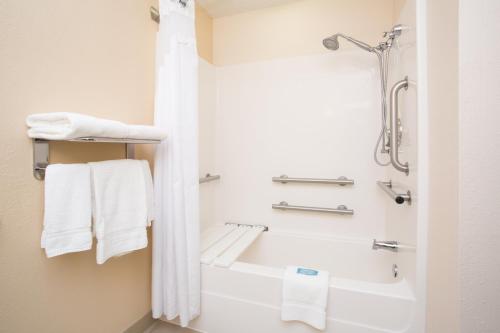 ein Bad mit einer Badewanne und einer Dusche mit Handtüchern in der Unterkunft Holiday Inn Express Hotel & Suites Concordia US 81, an IHG Hotel in Concordia