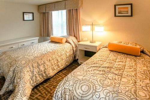 um quarto de hotel com duas camas e uma janela em Sea Mist Resort, a VRI resort em Mashpee
