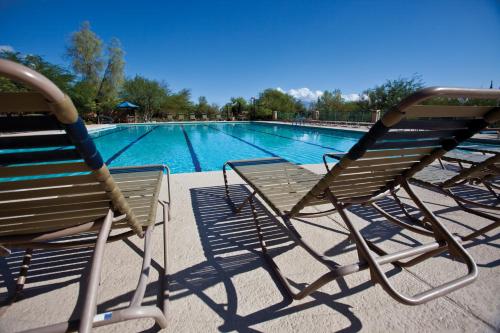 two chairs sitting next to a swimming pool at Starr Pass Golf Suites in Tucson
