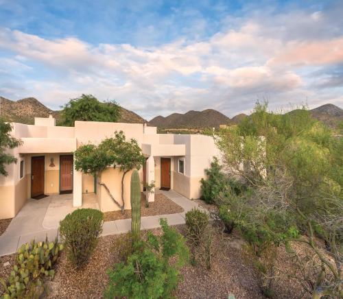 a house in the desert with mountains in the background at Starr Pass Golf Suites in Tucson