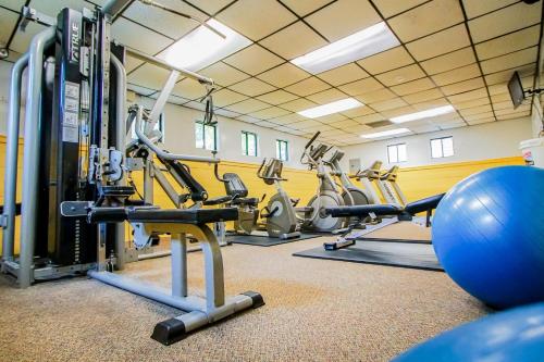 a gym with several tread machines and a ball at Sea Mist Resort in Mashpee